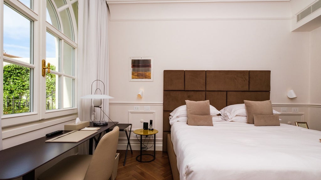 Elegant classic Italian hotel room with soft neutral tones, antique wooden furniture, and serene patio view in traditional Tuscan architectural style