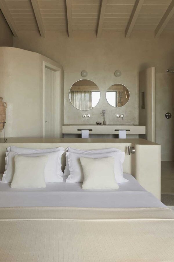 Luxurious minimalist hotel room with white decor, large windows, private pool view, and elegant Greek island design aesthetic in Kefalonia