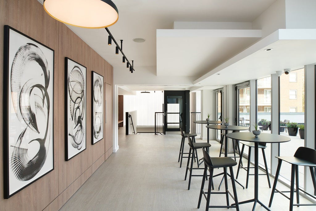 Elegant modern hotel lobby with sleek minimalist design, marble surfaces, contemporary furniture, and warm neutral color palette in London's Portman Square