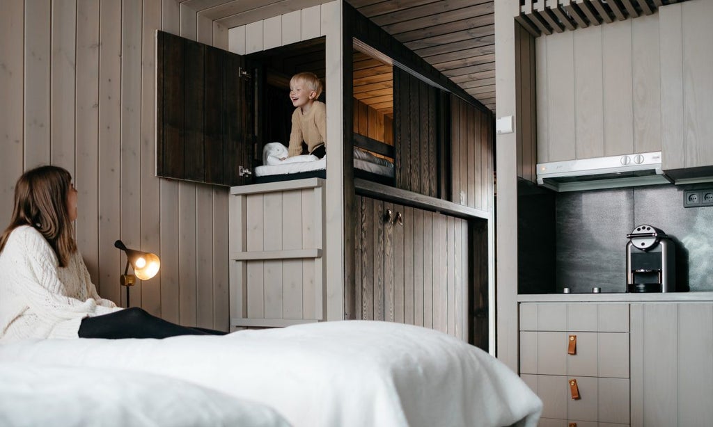 Modern luxury suite with panoramic windows overlooking snowy Nordic forest, featuring minimalist Nordic design and cozy warm interior with natural wood elements