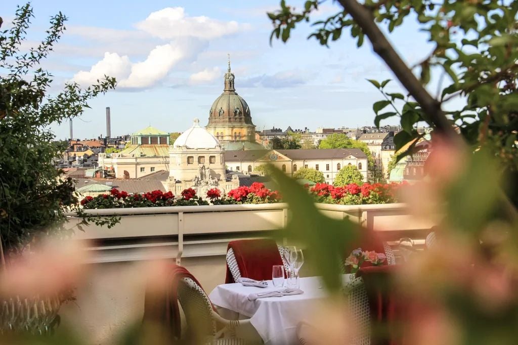 Elegant historic bank transformed into luxurious boutique hotel, featuring grand marble columns, ornate chandeliers, and refined architectural details in Stockholm