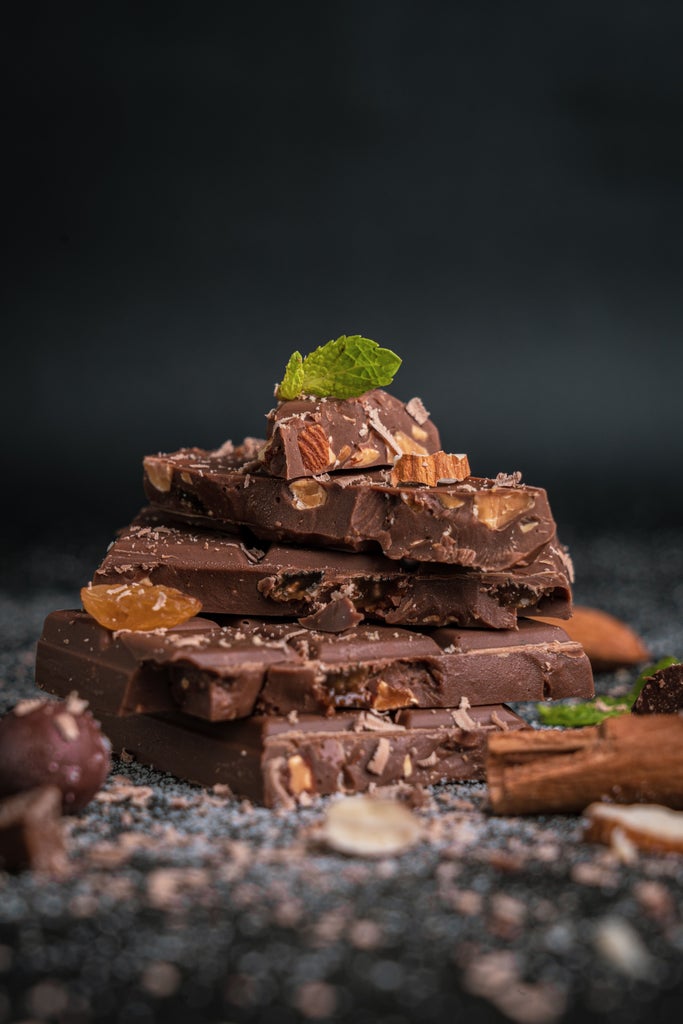 Elegant chocolate-making workshop in luxurious Zermatt, Swiss chocolatier carefully tempering dark chocolate with Matterhorn mountain view