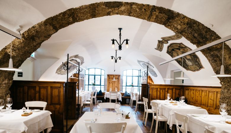 Historic 4-star hotel with ornate cream facade, wrought iron signage, and traditional Austrian architecture on a charming cobblestone street