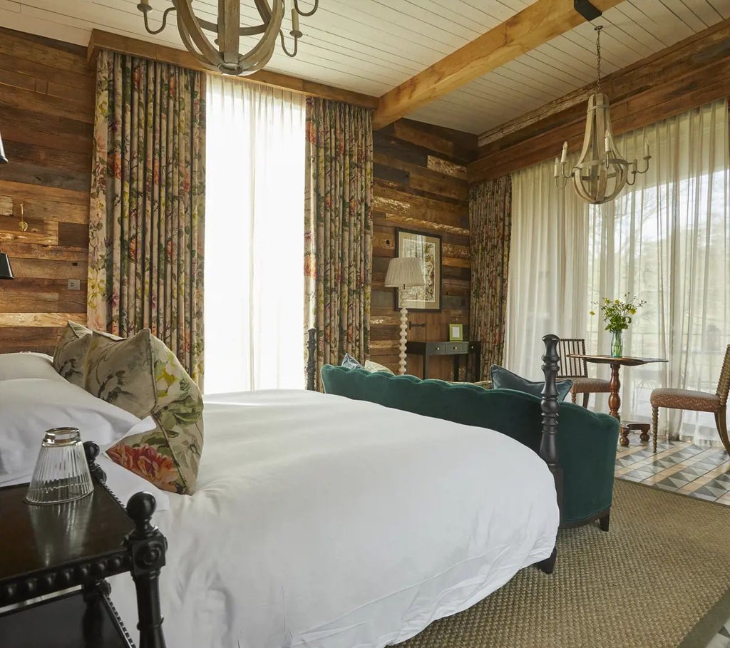 Luxurious wooden lake cabin with rustic-chic decor, plush king bed, floor-to-ceiling windows overlooking lush forest landscape at Lime Wood Hotel, New Forest, UK