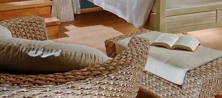 Luxurious white-walled villa bedroom with panoramic sea view, elegant wooden furniture, and crisp white linens overlooking Greek island coastline