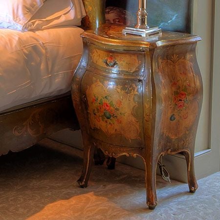 Elegant boudoir suite with plush king-sized bed, vintage chandelier, ornate cream-colored furnishings, and soft ambient lighting in a luxurious UK boutique hotel room