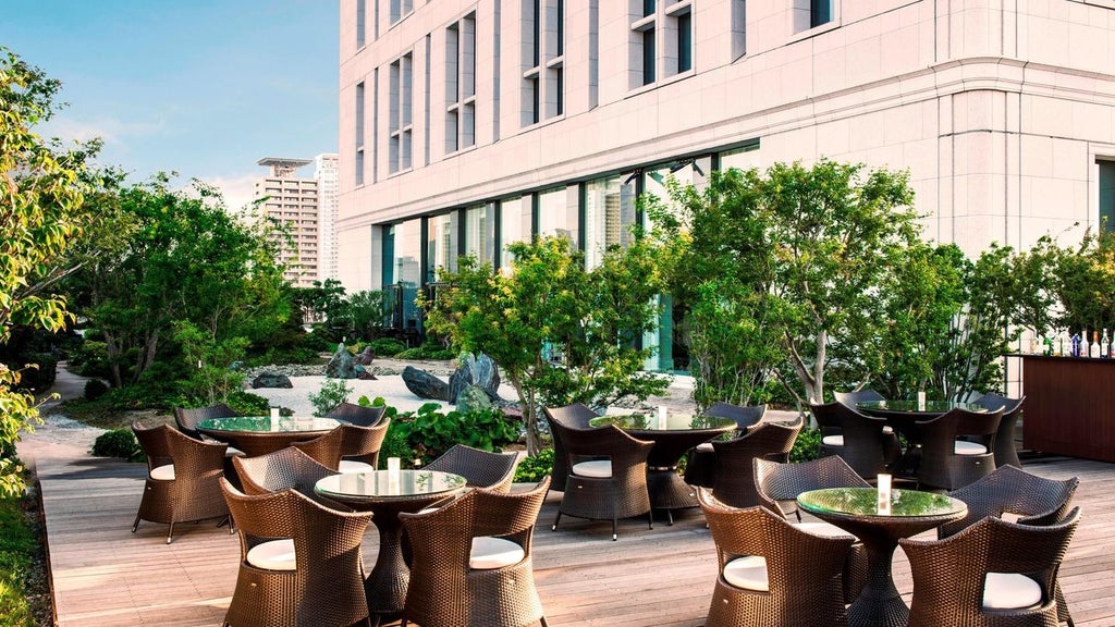 Luxurious lobby of The Scenset Hotel in Osaka, featuring elegant marble floors, contemporary chandeliers, and sleek modern design with Japanese aesthetic touches