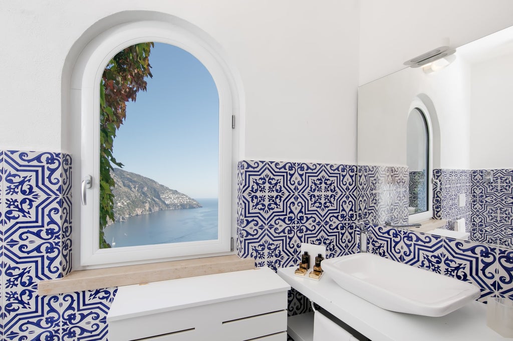 Elegant double room with panoramic sea views, private balcony, cream decor, tiled floors and modern luxury furnishings overlooking Positano