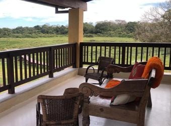 Luxurious master suite at Caiman Ecological Refuge, featuring elegant decor, crisp white linens, and expansive views of Brazilian wilderness landscape