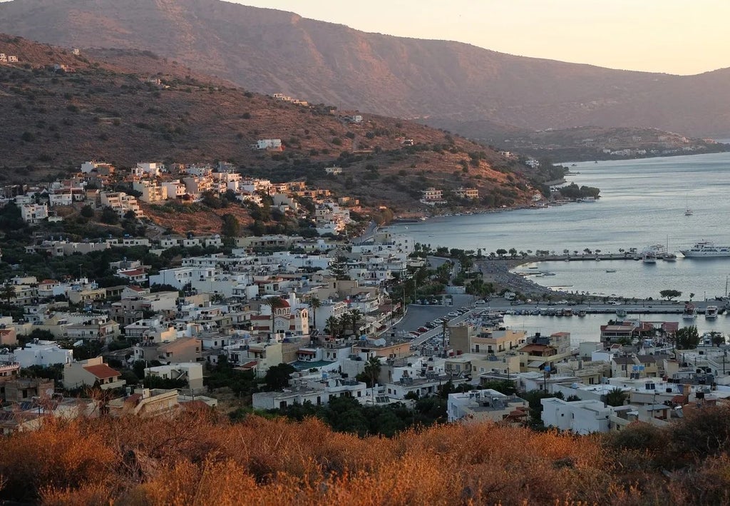 Luxurious white domed suites overlooking azure Aegean waters, with private infinity pools and Cretan landscape at Domes of Elounda resort