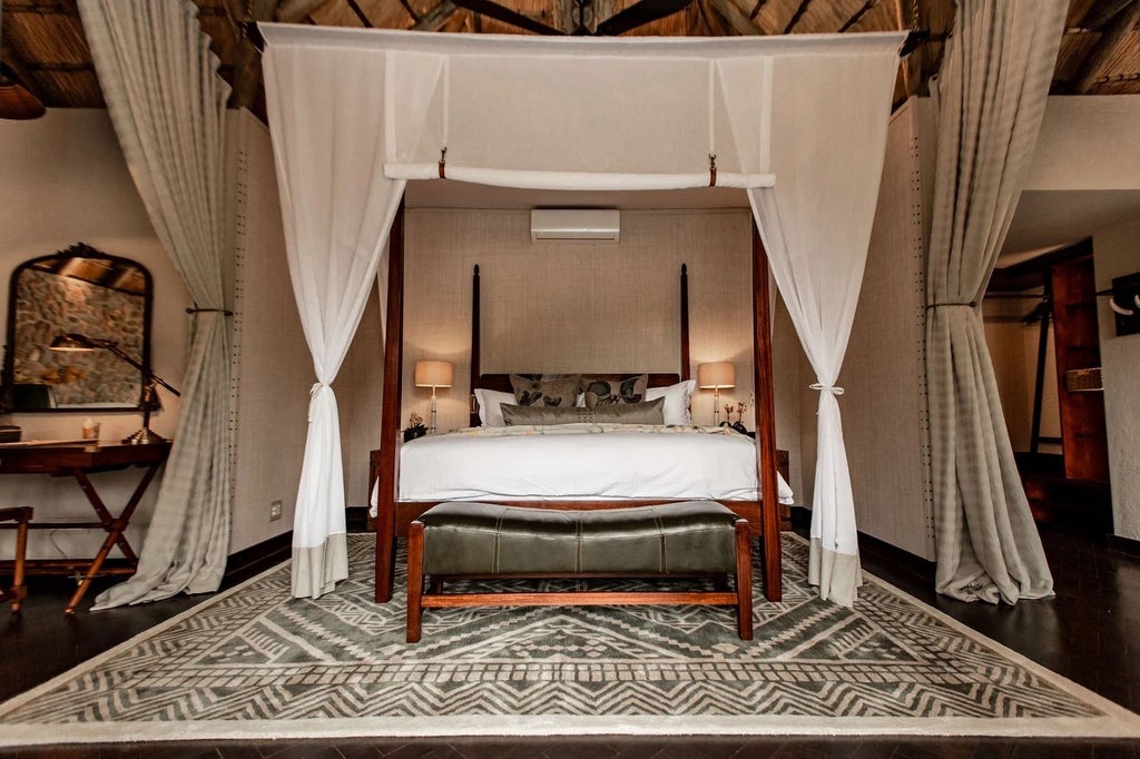 Elegant safari lodge with thatched roof overlooking a watering hole, surrounded by African bushveld at golden hour