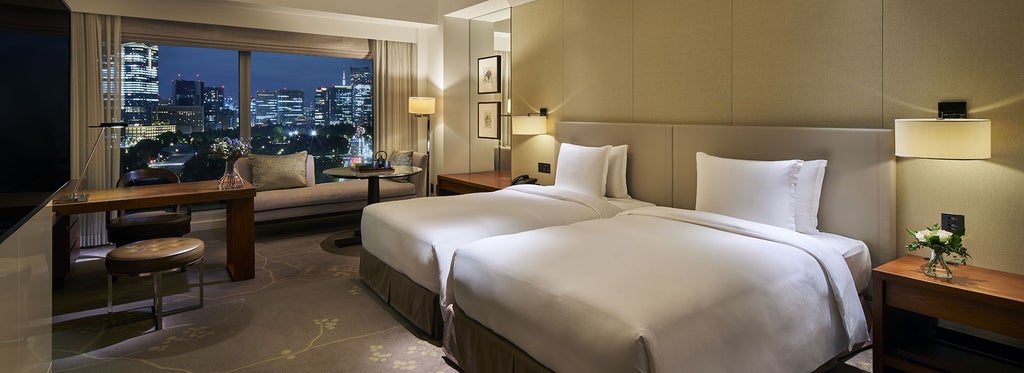 Luxurious twin/king hotel room at scenset Palace Hotel Tokyo, featuring elegant decor and expansive views of Wadakura Fountain Park through a private balcony window