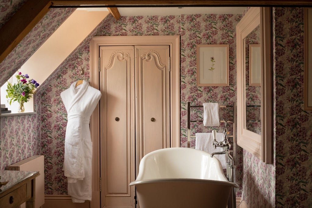 Luxurious hotel bedroom with soft green thyme-inspired decor, crisp white linens, elegant wooden furniture, and soft ambient lighting in a refined UK setting