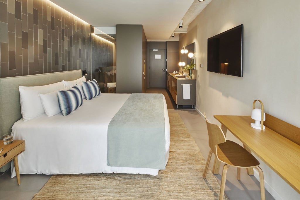 Minimalist Barcelona hotel room with elegant white decor, modern design, plush bed, and sleek bathroom in warm neutral tones at Ohla Eixample