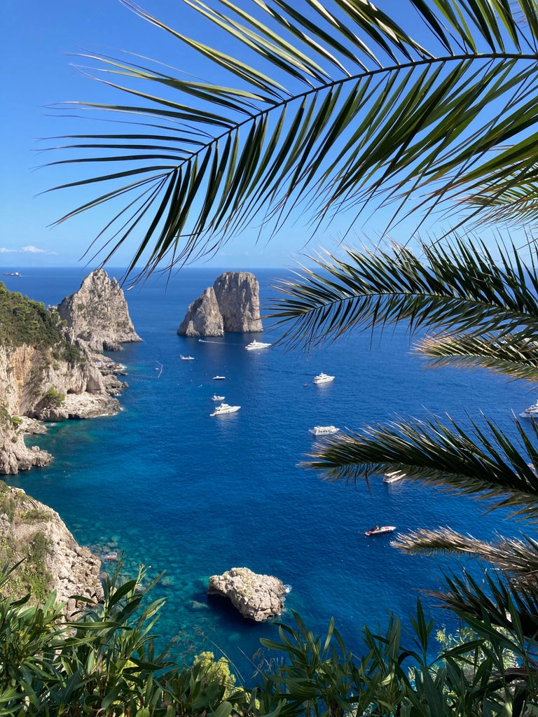 Luxurious villa perched on Capri's cliffside with panoramic Mediterranean views, sunlit terrace, and elegant stone architecture