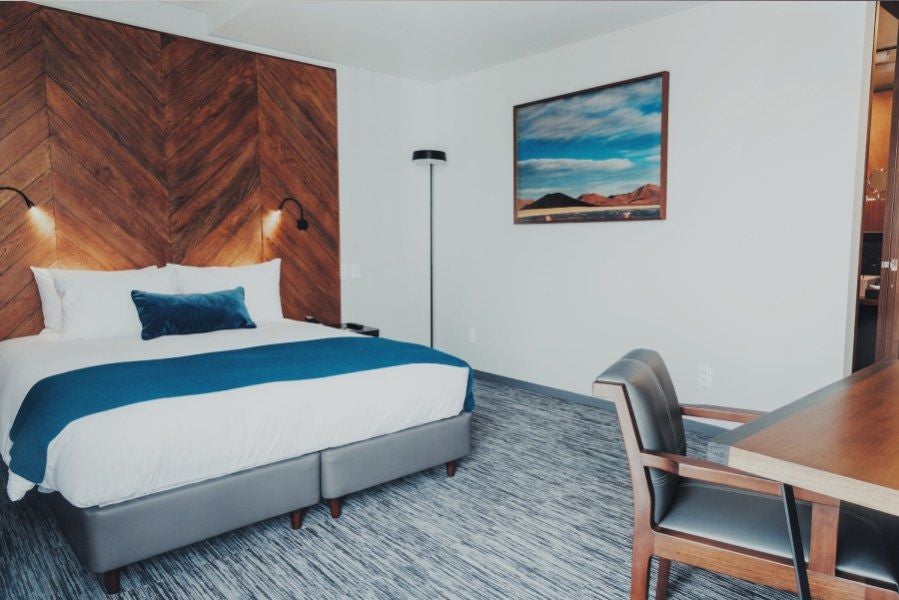 Spacious Atix Suite with sleek modern design, featuring minimalist gray color palette, contemporary furniture, and panoramic city view of La Paz skyline