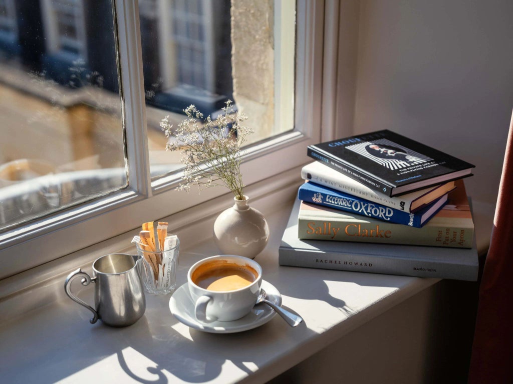 Elegant classic-style hotel room with wooden furnishings, crisp white linens, antique desk, and subtle period details in a historic UK setting