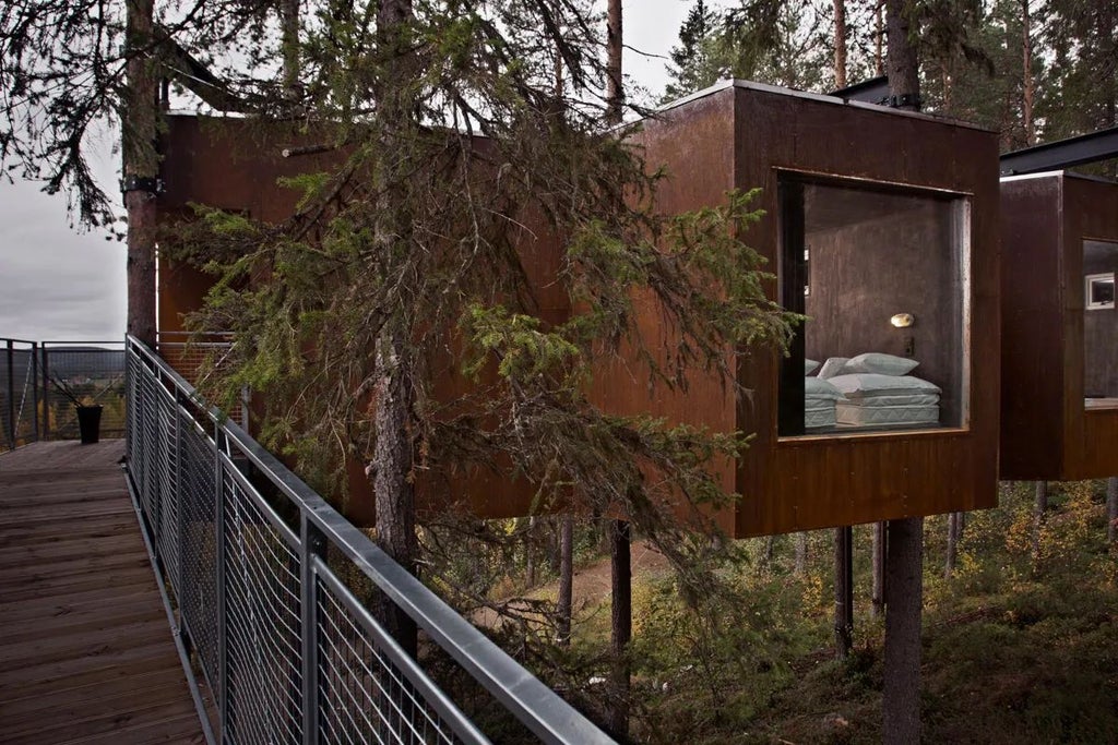 Modern mirrored rectangular hotel room suspended among pine trees, reflecting forest landscape with sleek metallic exterior and minimalist architectural design in Swedish woodland setting