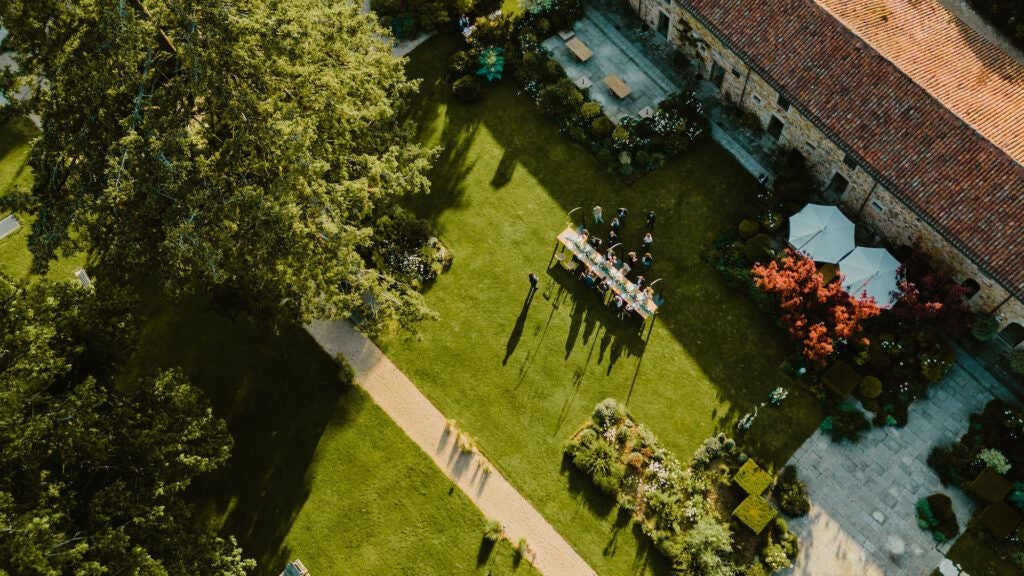 Serene luxury château nestled in lush French countryside, featuring stone architecture, manicured gardens, and tranquil reflecting pond at golden hour