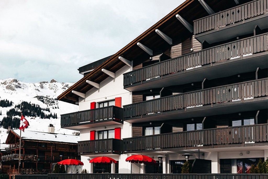 Luxurious alpine chalet with panoramic mountain views, featuring modern minimalist design, warm wood tones, and elegant floor-to-ceiling windows overlooking Swiss landscape