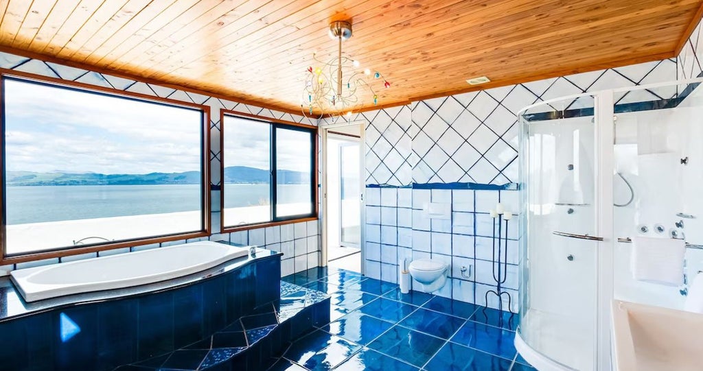 Spacious 4-bedroom luxury villa with panoramic lake and mountain views, modern open-plan design, expansive windows, and elegant contemporary furnishings in New Zealand