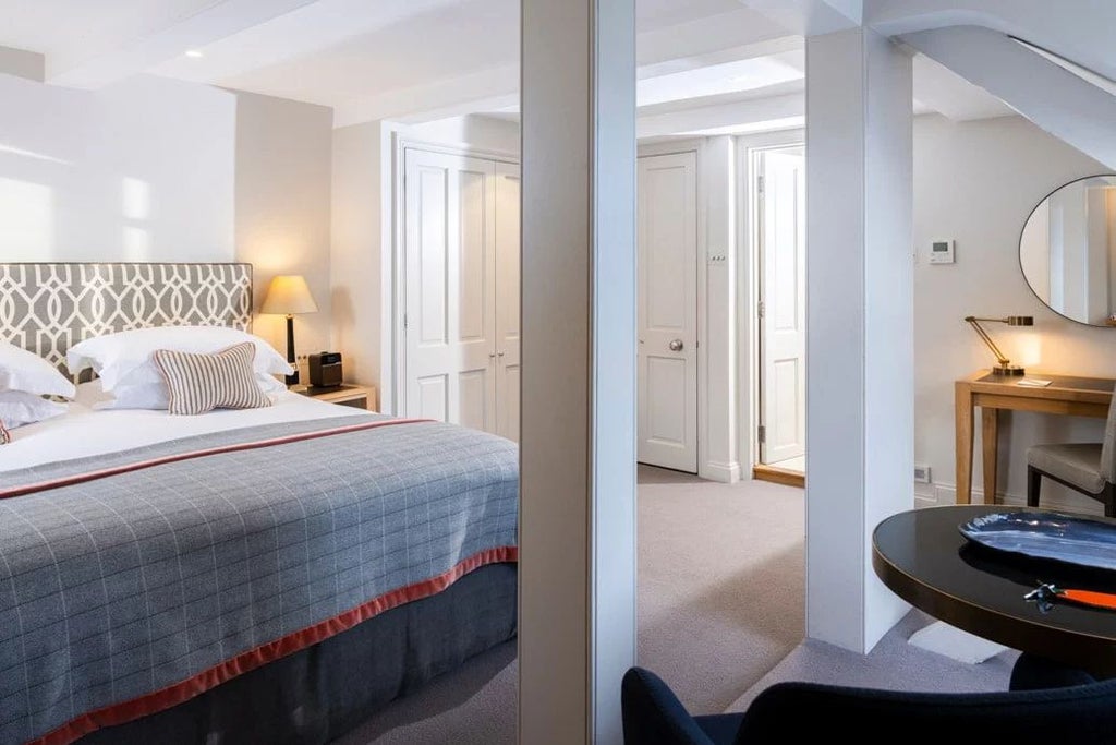 Elegant superior deluxe hotel room with private balcony, featuring refined vintage decor, luxurious bedding, and classic architectural details in a historic United Kingdom setting.