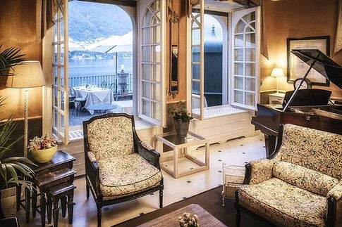 Elegant Lake Como villa with terracotta-tiled roof, lush gardens, and panoramic waterfront views showcasing Italian Renaissance architectural splendor