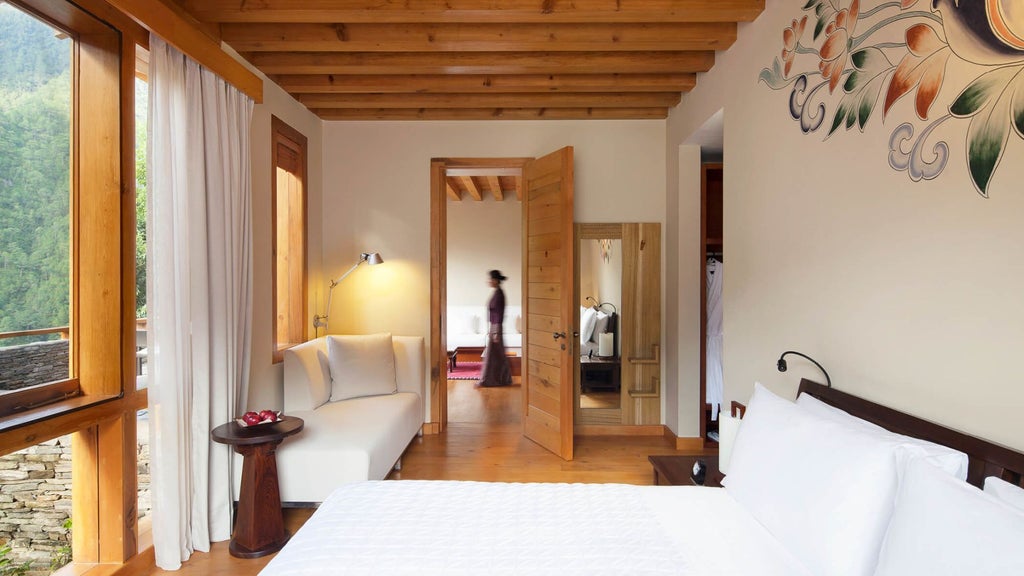 Luxurious COMO Villa bedroom in Punakha, Bhutan, with traditional architectural details, elegant furnishings, and panoramic mountain valley views through large windows.