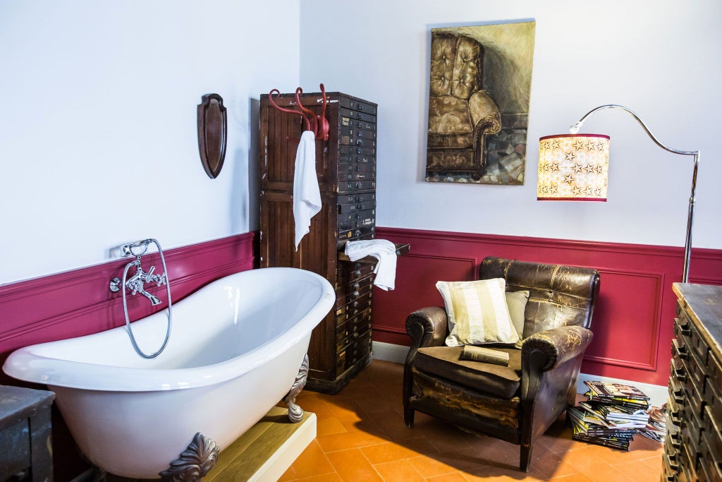 Elegant Tuscan-style deluxe hotel room with exposed wooden beams, antique furnishings, and soft natural light in a historic Florence boutique suite