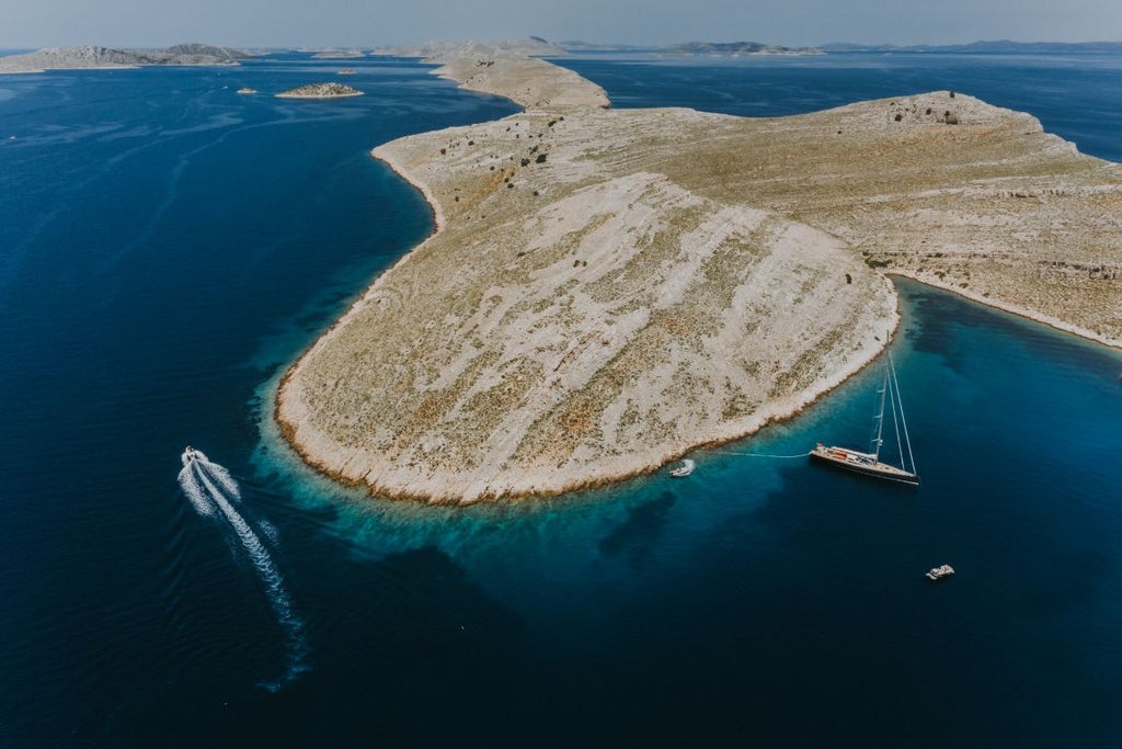 Luxurious waterfront resort with modern architecture overlooking azure Adriatic Sea, featuring sleek white buildings nestled against scenic Croatian coastline