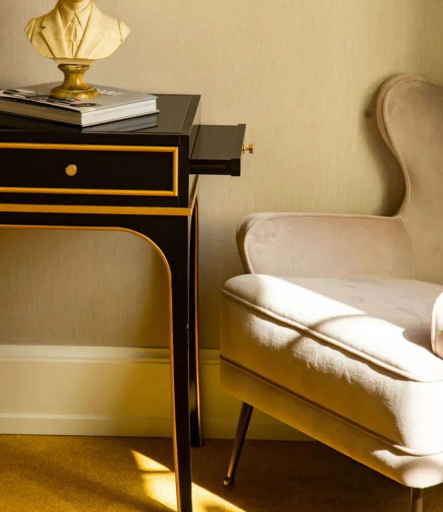 Elegant prestige hotel room with ornate gold-framed mirrors, rich fabric headboard, marble side tables and classic Italian decor details