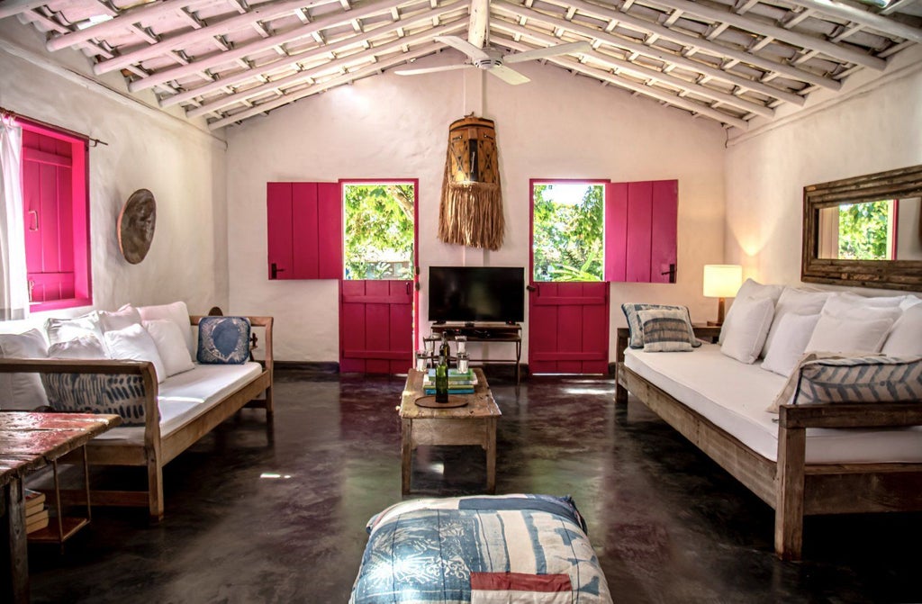 Rustic luxe Brazilian hotel room with wooden furniture, white linens, and traditional design at scenset Casa Hotel and Spa in Trancoso, Bahia