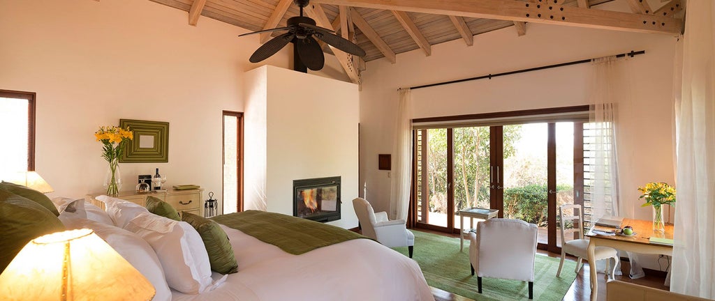 Luxurious minimalist hotel room with panoramic vineyard views, elegant neutral tones, and modern Chilean wine country design at Clos Apalta Residence