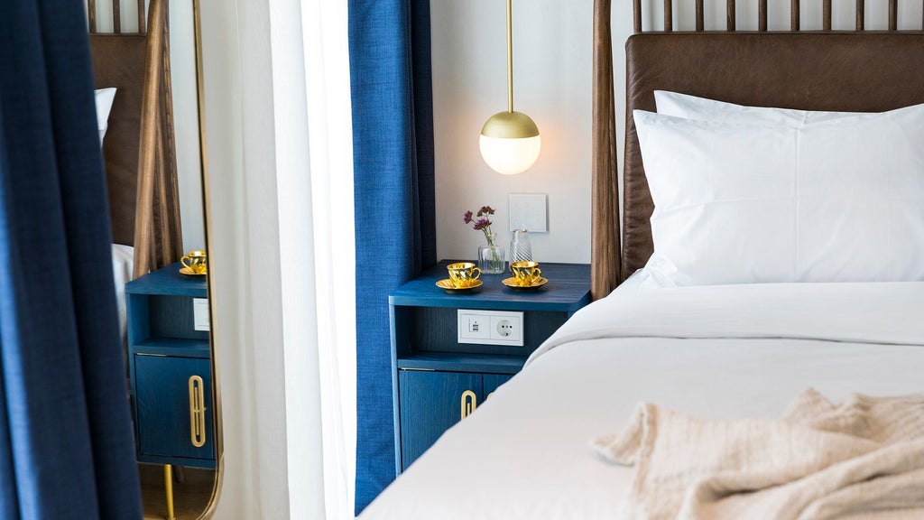 Elegant junior suite with modern minimalist design, white marble elements, king-sized bed, city skyline view, characteristic of luxurious Athenian hospitality