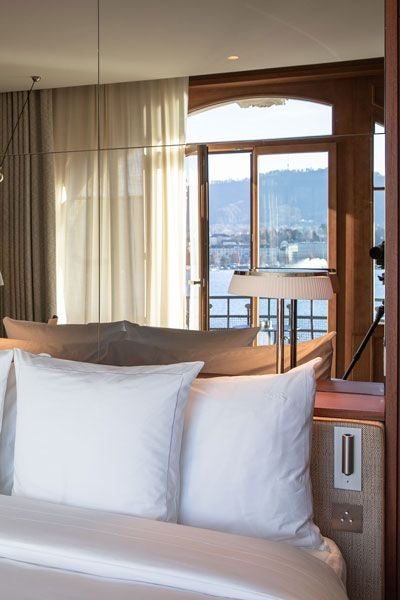 Elegant lake view hotel room at La Réserve Eden au Lac Zurich, featuring luxurious Swiss decor with expansive windows overlooking Lake Zurich's pristine waters