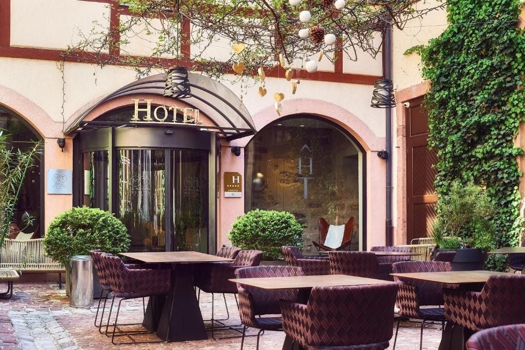 Historic French Renaissance hotel with ornate carved stone faces adorning its facade, featuring elegant windows and classic architecture