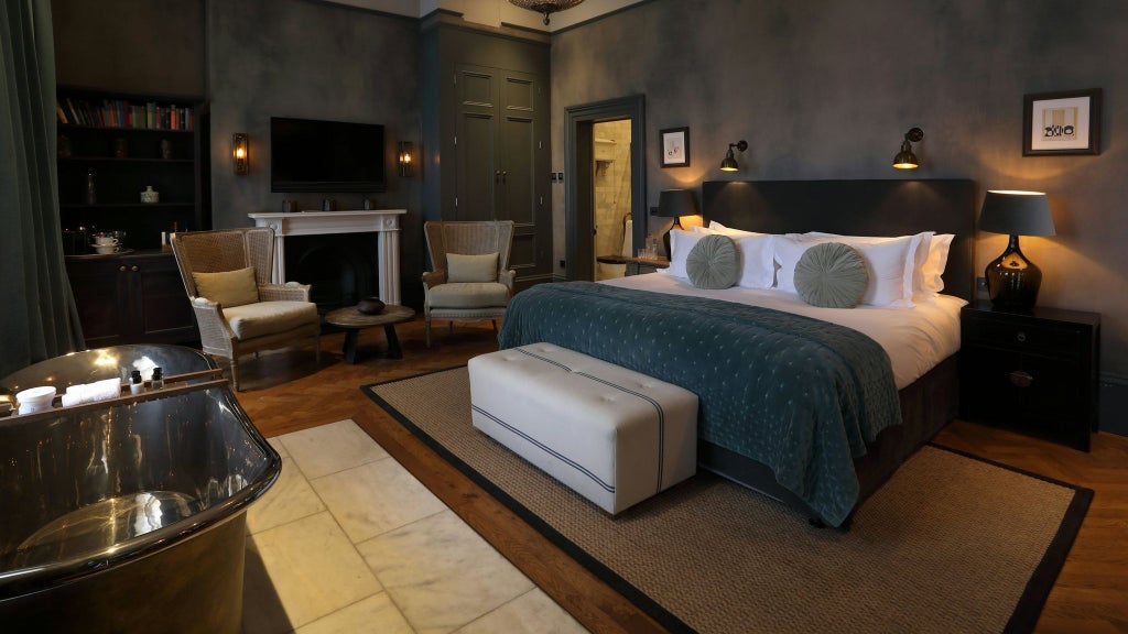 Luxurious hotel room with elegant contemporary design, plush bedding, warm neutral tones, and sophisticated minimalist decor in a premium UK accommodation