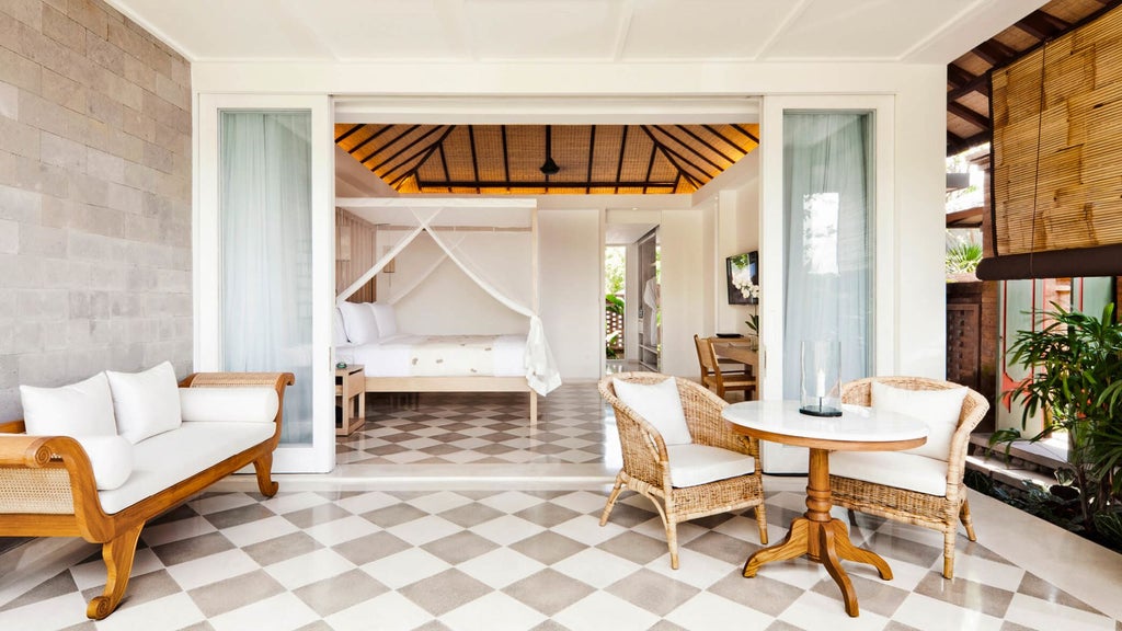 Modern Balinese terrace room with king bed, white linens, dark wood furnishings, private balcony overlooking tropical jungle canopy