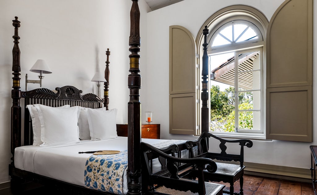 Colonial-era luxury hotel Amangalla in Galle Fort, featuring grand white facade with palm trees and antique wooden shuttered windows