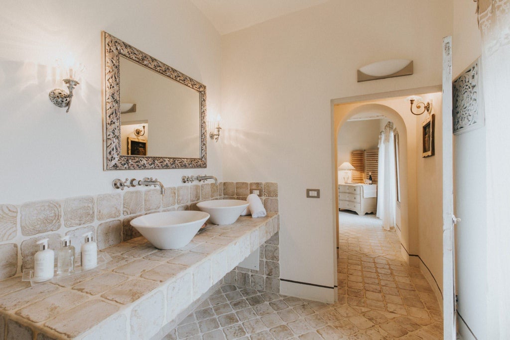 Elegant deluxe double room at a luxury hotel in Italy, featuring plush white bedding, contemporary decor, and soft natural lighting from large windows