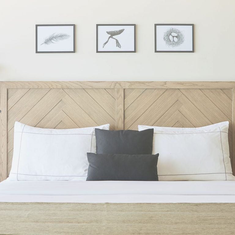 Elegant double bedroom with minimalist design, white linens, wooden floors, and large windows overlooking lush Greek landscape at ELIVI Skiathos hotel