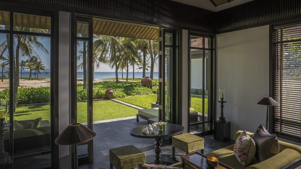 Beachfront villa at Four Seasons Nam Hai resort features infinity pool overlooking pristine shoreline, surrounded by tropical gardens