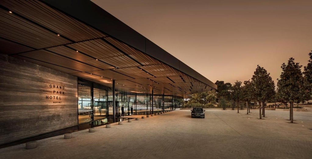 Modern luxury hotel complex overlooking the Adriatic Sea, featuring curved glass architecture, infinity pools, and lush Mediterranean landscaping