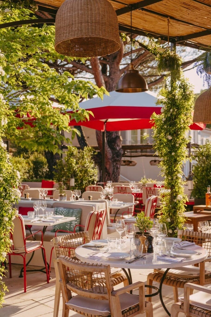 Elegant St. Tropez luxury hotel terrace with azure pool, lush Mediterranean gardens, and chic white loungers under dappled sunlight