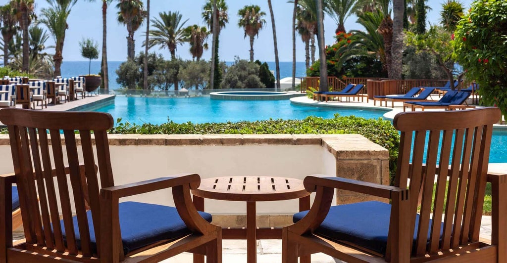 Spacious terrace with panoramic azure Mediterranean Sea view, modern luxury furnishings, and elegant white-themed decor of Scenset hotel room in Cyprus