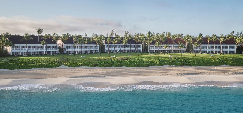 Elegant oceanfront resort with Mediterranean-style architecture, infinity pools and private beach surrounded by swaying palm trees