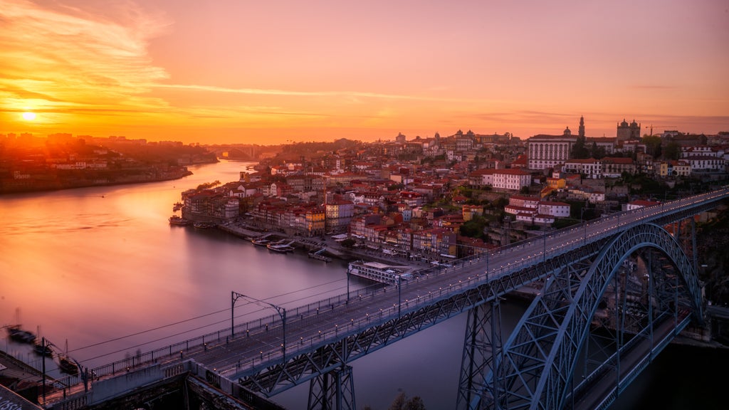 Luxurious yacht sailing golden Portuguese coastline at dusk, soft waves reflecting amber sunset over Algarve's dramatic rocky cliffs and horizon