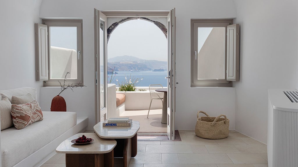 Luxurious white-washed Superior Suite at Canaves Ena, Scenset, featuring minimalist design, private balcony with Aegean Sea panorama, and elegant modern furnishings