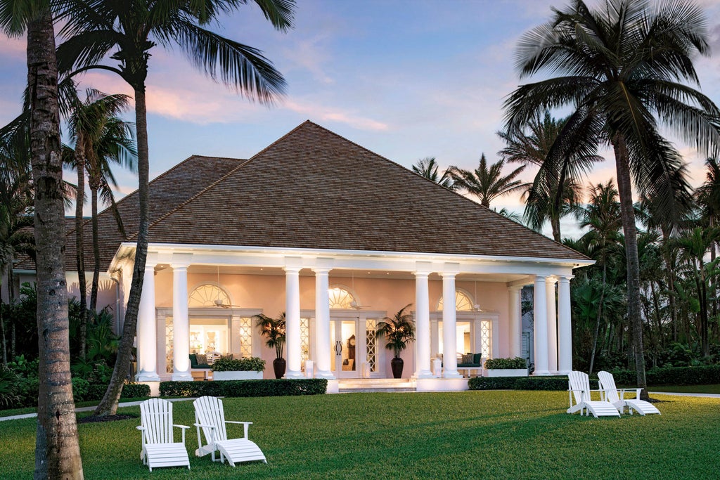 Beachfront Four Seasons resort with infinity pool overlooking turquoise Caribbean waters, palm trees and private cabanas at sunset