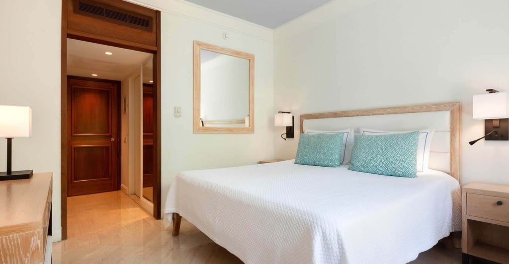 Spacious connecting inland view rooms at a luxurious Cyprus hotel, featuring modern decor, plush beds, and elegant neutral color palette with warm lighting